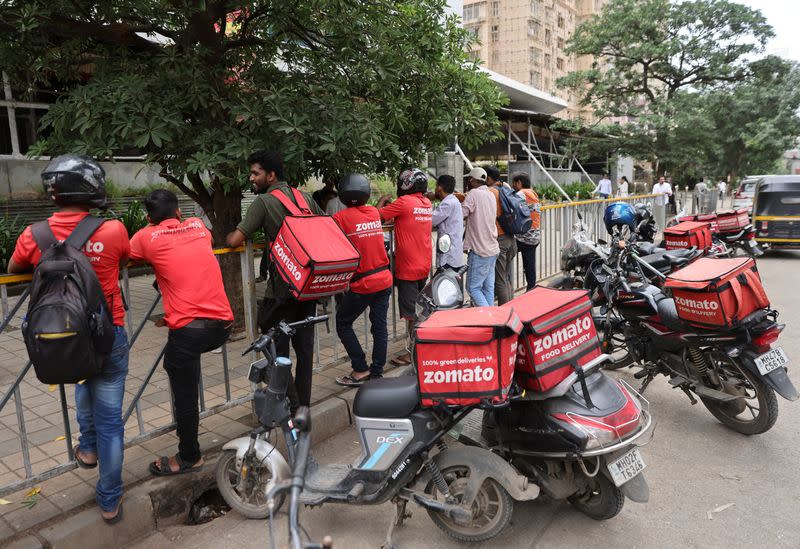 Gig workers wait in line to collect their delivery order outside a mall in Mumbai,