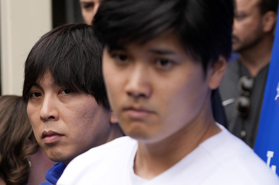 FILE - Ippei Mizuhara stands next to Japanese baseball star Shohei Ohtani and translates during an interview at Dodger Stadium on Feb. 3, 2024. The former longtime interpreter for Los Angeles Dodgers star Shohei Ohtani has been charged with federal bank fraud for crimes involving gambling debts and theft of millions of dollars from the slugger. Federal authorities announced the development Thursday, April 11, at a press conference in Los Angeles. (AP Photo/Richard Vogel, File)