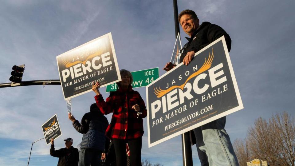 Incumbent Eagle Mayor Jason Pierce waves to commuters Tuesday at rush hour with supporters at the corner of Eagle Road and Highway 44.