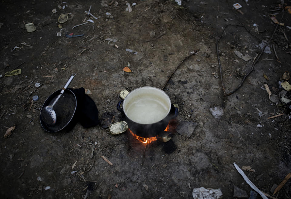 In this Sunday, Nov. 18, 2019 photo a cooking pot is placed on a fire outdoors at a camp in Velika Kladusa, Bosnia, close to the border to Croatia. The approach of the tough Balkan winter spells tough times for the migrants that remain stuck in the region while trying to reach Western Europe, with hundreds of them staying in make-shift camps with no heating or facilities.(AP Photo/Amel Emric)