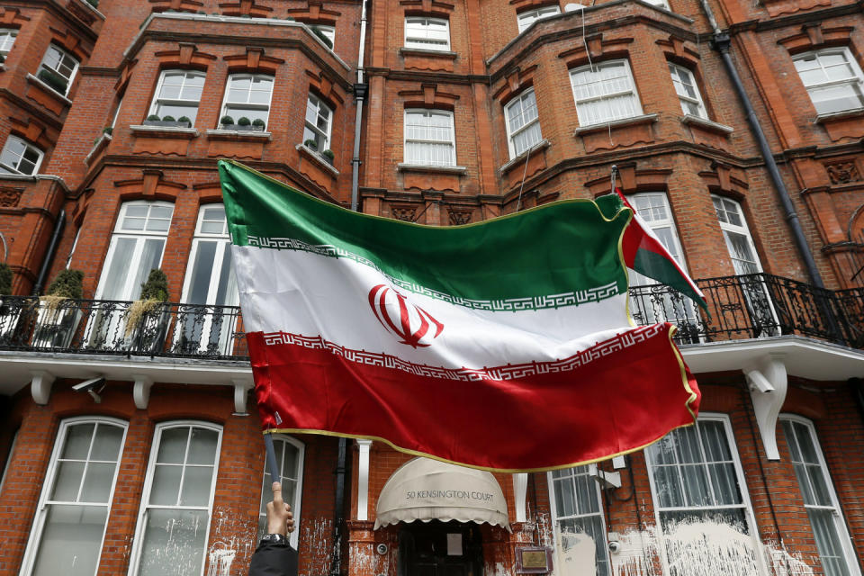 A voter holds a flag outside the Iranian consulate in central London June 14, 2013. The building was the focus for demonstrators, as it was used as a venue for British based Iranians to cast their vote in their country's election to choose a new president. REUTERS/Stefan Wermuth 