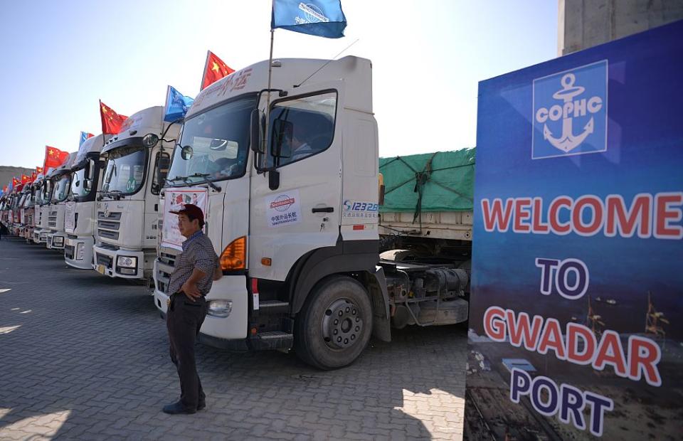 A Chinese worker stands near trucks carrying goods during the opening of a trade project in Gwadar port, some 700 kms west of the Pakistani city of Karachi on November 13, 2016.<span class="copyright">AAMIR QURESHI/AFP via Getty Images</span>