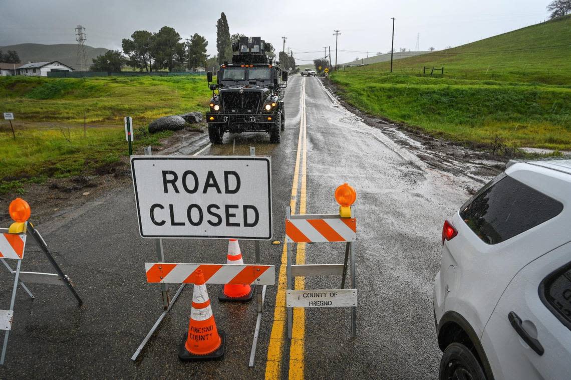 A Clovis Police Department SWAT vehicle stands by at a Fresno County Sheriff’s Department roadblock at Elwood Road and Piedra Road in eastern Fresno County on Friday, March 10, 2023. The vehicle was in place to potentially help rescue flood victims as the road had washed out in heavy rain and runoff.