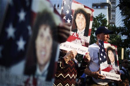 Family and friends of Wayne A. Russo hold his images while attending the 9/11 Memorial ceremonies marking the 12th anniversary of the 9/11 attacks on the World Trade Center in New York on September 11, 2013. REUTERS/Adrees Latif