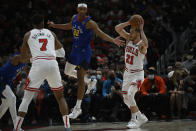 Chicago Bulls guard Matt Thomas (21) passes the ball past Denver Nuggets forward Zeke Nnaji (22) as Bulls forward Troy Brown Jr. (7) looks on during the first half of an NBA basketball game Monday, Dec. 6, 2021, in Chicago. (AP Photo/Matt Marton)