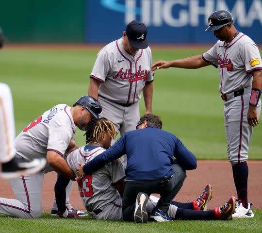 <p>AP Photo/Gene J. Puskar</p> Ronald Acuña Jr. (center) being treated on the field