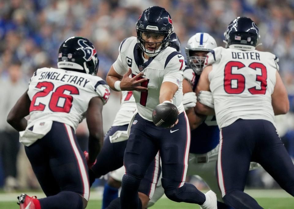 Houston Texans quarterback C.J. Stroud (7) looks to hand the ball off to Houston Texans running back Devin Singletary (26) on Saturday, Jan. 6, 2024, during a game against the Houston Texans at Lucas Oil Stadium in Indianapolis.