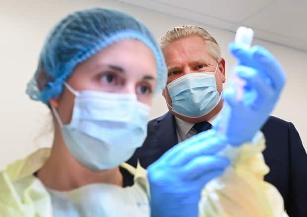 Ontario Premier Doug Ford watches a health-care worker prepare a dose of the Pfizer-BioNTech COVID-19 vaccine at a UHN vaccine clinic in Toronto on Thursday, January 7, 2021. 