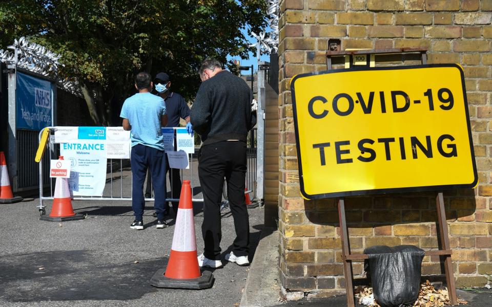 People queue up outside a coronavirus testing centre offering walk-in appointments in east London - PA/PA