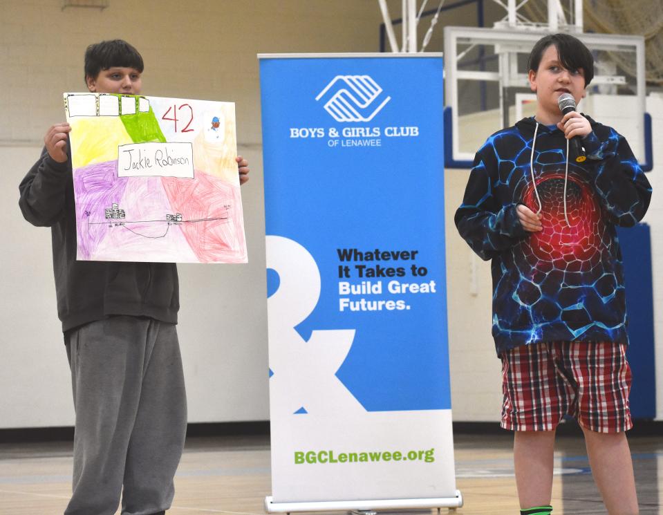 Collin Mathis, right, a sixth grade student at Springbrook Middle School in Adrian, is assisted by Springbrook seventh grader Leland McPherson, left, while taking about Jackie Robinson, who was the person Mathis chose to study for the Boys & Girls Club of Lenawee's inaugural Black History Month biography fair. Mathis and McPherson were two of six students who presented their biography projects publicly.