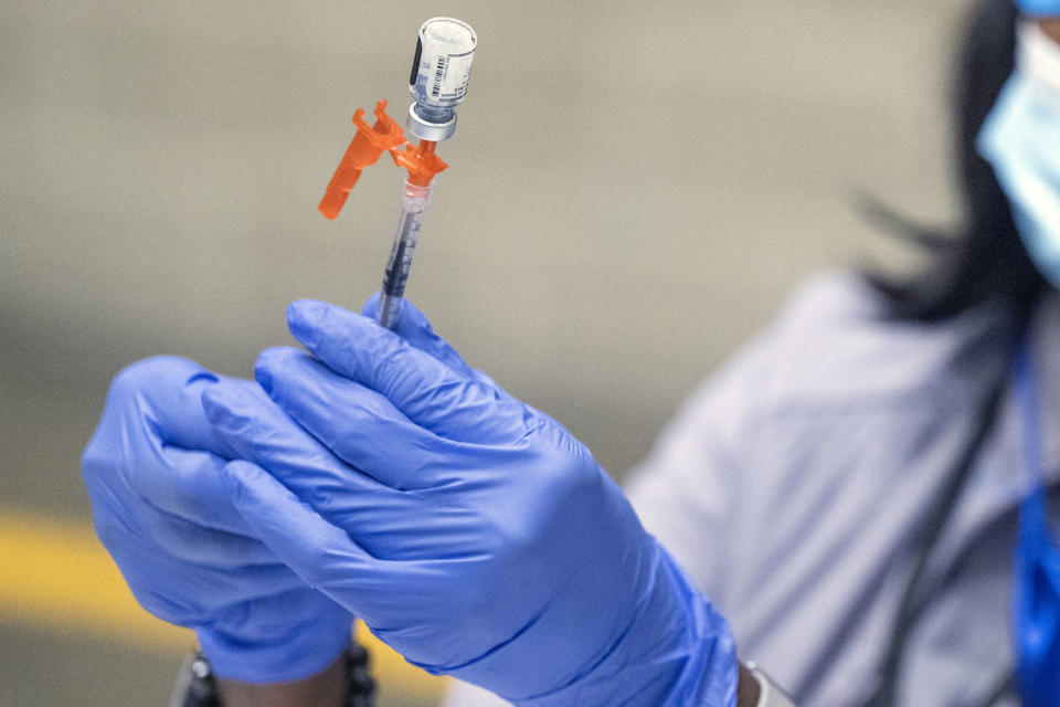 A nurse prepares a COVID booster shot.