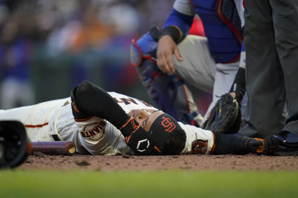 San Francisco Giants' Thairo Estrada remains on the ground after being hit by a pitch during the fifth inning of the team's baseball game against the Chicago Cubs in San Francisco, Saturday, July 30, 2022. (AP Photo/Godofredo A. Vásquez)