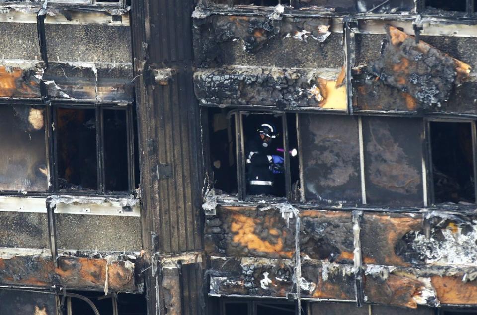Fire service personnel survey the damage to Grenfell Tower (Rick Findler/PA) (PA Archive)