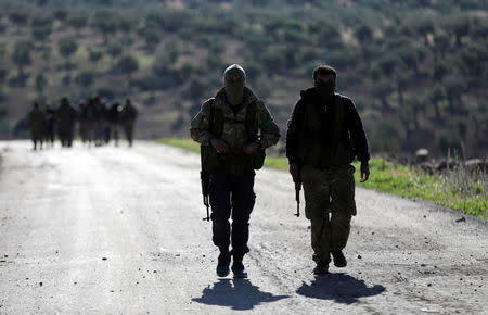 Turkish-backed Free Syrian Army fighters walk after advancing north of Afrin, Syria March 17, 2018. REUTERS/Khalil Ashawi