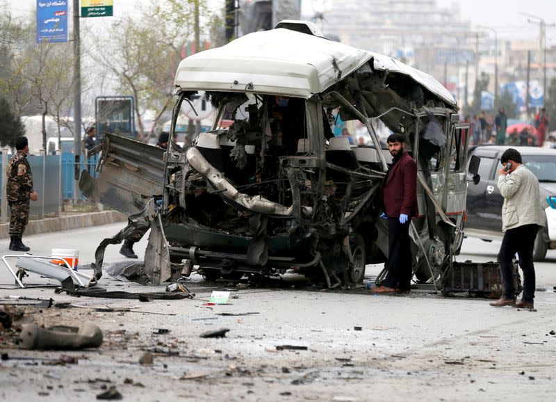 FILE PHOTO: Afghan officials inspect a damaged minibus after a blast in Kabul