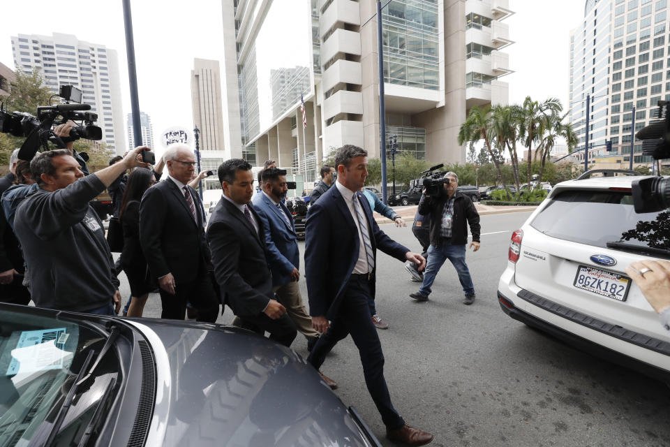 California Republican Rep. Duncan Hunter, center right, walks out of federal court Tuesday, Dec. 3, 2019, in San Diego. Hunter gave up his year-long fight against federal corruption charges and pleaded guilty Tuesday to misusing his campaign funds, paving the way for the six-term Republican to step down. (AP Photo/Gregory Bull)