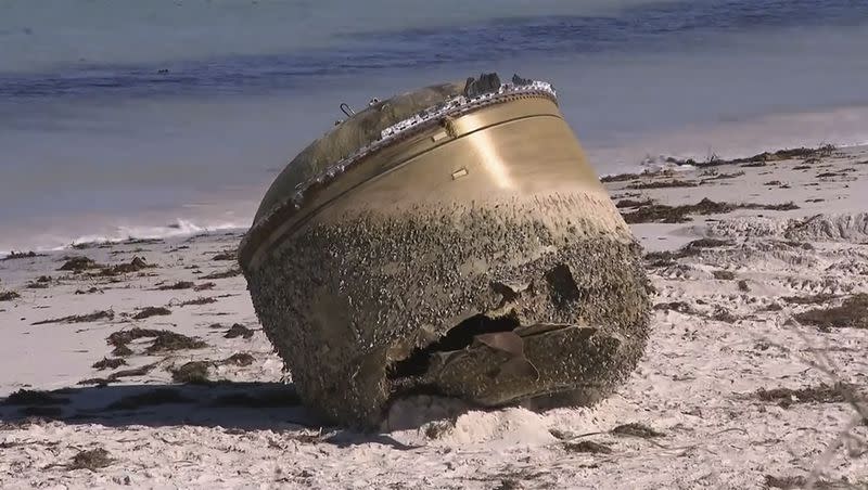 In this image made from video, a cylindrical object is seen on the beach in Green Head, Australia, on July 17, 2023. Authorities were investigating whether a cylindrical object about the size of a small car that washed up on a remote Australian beach is space junk from a foreign rocket.