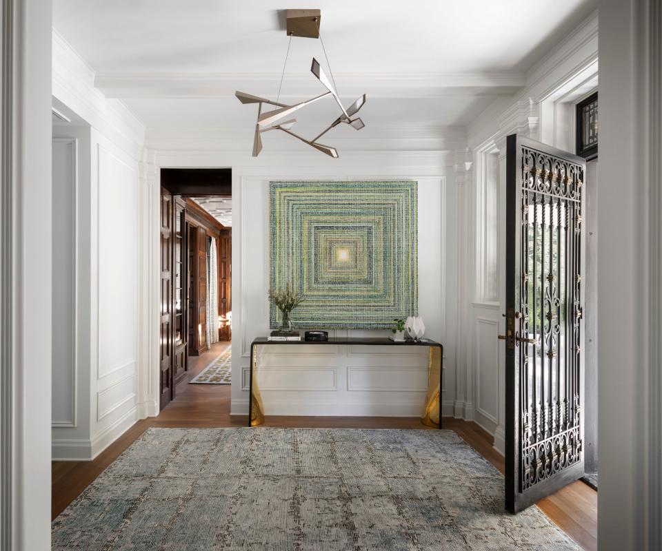 entrance foyer with wooden floor and door open and console with artwork above