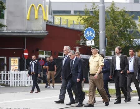 Bavarian state Interior Minister Joachim Herrmann and German Interior Minister Thomas De Maiziere (2nd L) visit a scene near the Olympia shopping mall, where yesterday's shooting rampage started, in Munich, Germany July 23, 2016. REUTERS/Arnd Wiegmann