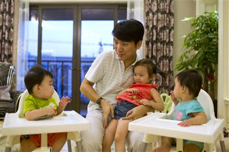 Tony Jiang poses with his three children at his house in Shanghai September 16, 2013. REUTERS/Aly Song