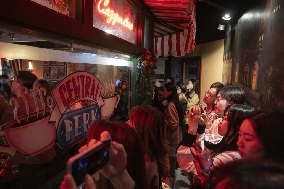 Fans of the hit sit-com "Friends" gather at a cafe that pays homage to the Central Perk cafe in the series, to mourn the death of Matthew Perry who played the Chandler Bing character, in Shanghai, Wednesday, Nov. 1, 2023. Long before "Friends" made its official debut in China, the show was a word-of-mouth phenomenon in the country. In the wake of Matthew Perry's death at 54, fans in China are mourning the loss of the star who felt less like a distant celebrity and more like an old friend. (AP Photo/Ng Han Guan)