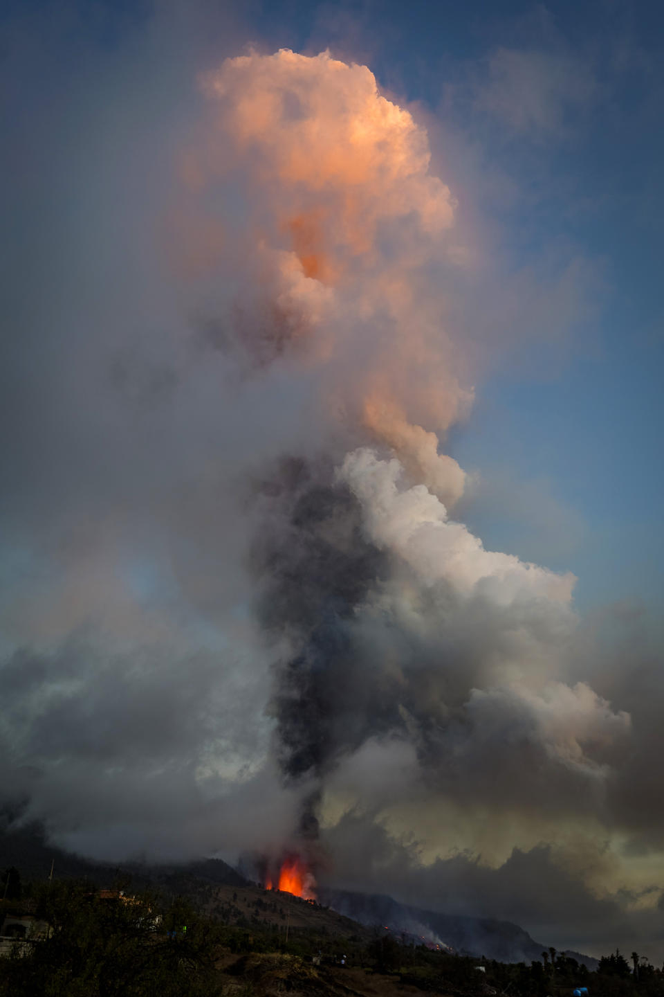 Lava and smoke flow from an eruption of a volcano at the island of La Palma in the Canaries, Spain, Sunday, Sept. 19, 2021. A volcano on Spain's Atlantic Ocean island of La Palma erupted Sunday after a weeklong buildup of seismic activity, prompting authorities to evacuate thousands as lava flows destroyed isolated houses and threatened to reach the coast. New eruptions continued into the night. (AP Photo/Jonathan Rodriguez)