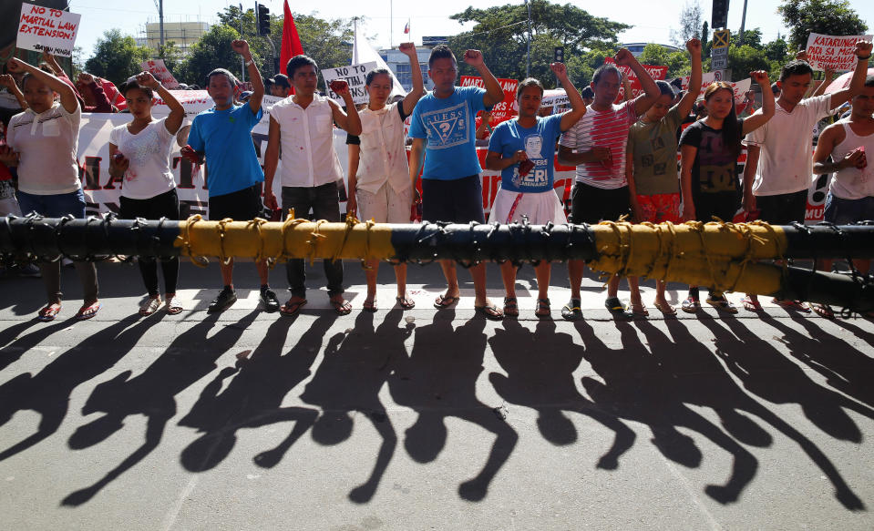 In this Wednesday, Dec. 12, 2018, file photo, protesters clench their fists during a rally at the Lower House to coincide with the joint Senate and Congress vote for the third extension of martial law in southern Philippines in suburban Quezon city, northeast of Manila, Philippines. In their statement, various opposition groups condemned the extension of Martial Law which allegedly will "lead to untimely death of more community leaders, human rights defenders, Indigenous Peoples, and Muslim opposition groups." (AP Photo/Bullit Marquez)