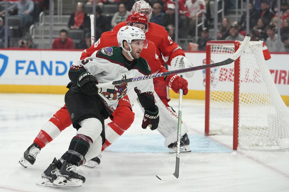 Arizona Coyotes center Alex Kerfoot (15) skates by Detroit Red Wings defenseman Jeff Petry during the first period of an NHL hockey game, Thursday, March 14, 2024, in Detroit. (AP Photo/Carlos Osorio)