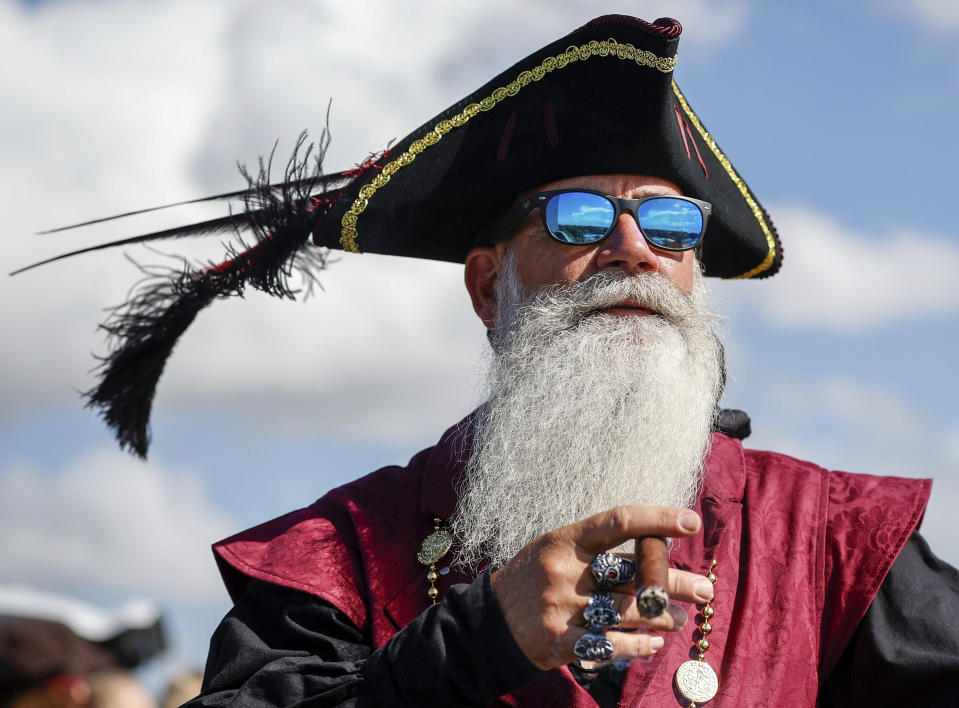 Robert Saliva, 53, of Tampa, smokes a cigar while taking in the festivities before the start of the Gasparilla Invasion on Saturday, Jan. 27, 2024, in Tampa. (Louis Santana/Tampa Bay Times via AP)