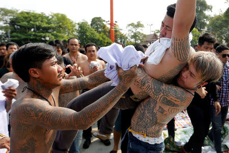 A devotee in trance is calmed down during a religious tattoo festival at Wat Bang Phra, where devotees come to recharge the power of their sacred tattoos, in Nakhon Pathom province, Thailand, March 11, 2017. REUTERS/Jorge Silva