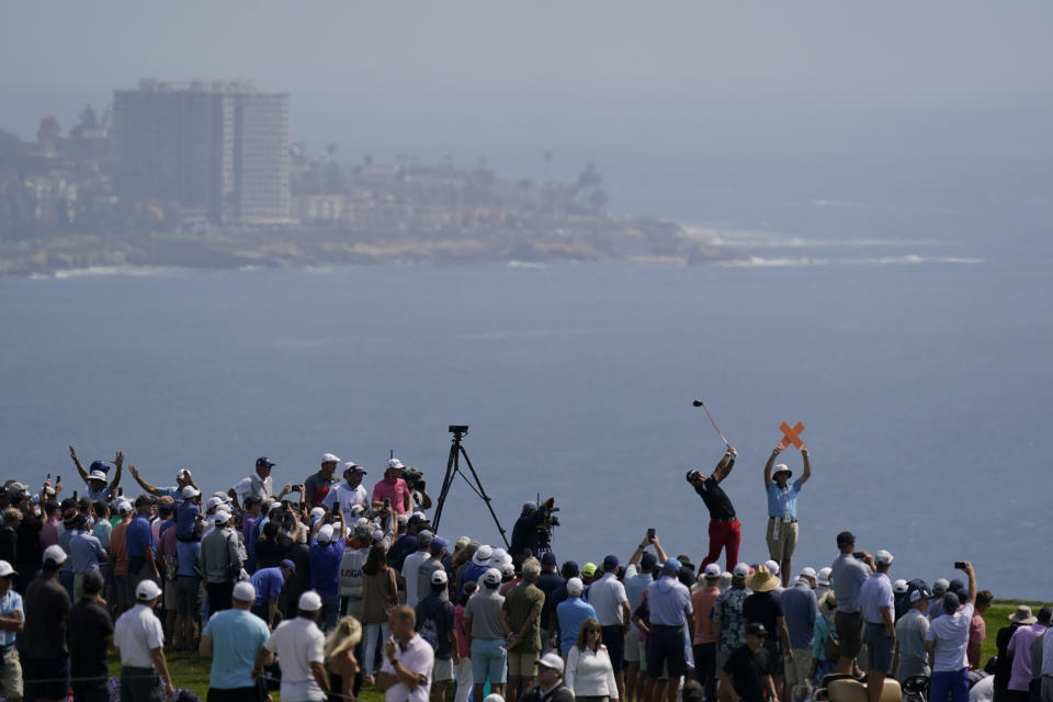 Fans watch as Hideki Matsuyama, of Japan, plays his shot from the fourth tee during the first round of the U.S. Open Golf Championship, Thursday, June 17, 2021, at Torrey Pines Golf Course in San Diego. (AP Photo/Gregory Bull)