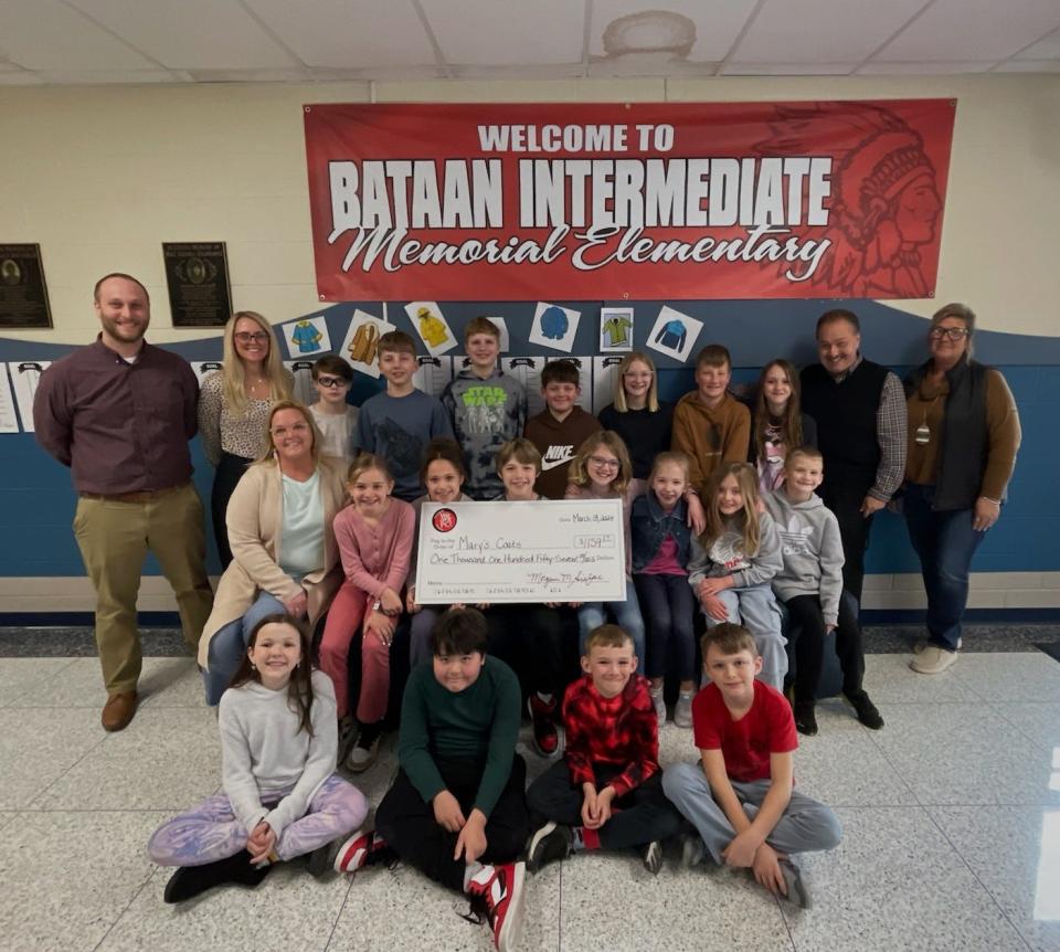 Bataan Memorial Intermediate students and staff present a check for $1,159.57 to Mike Ferdinandsen, grade 3 teacher, for Mary’s Coats for Kids Foundation established in memory of his mother Mary Ferdinandsen.
