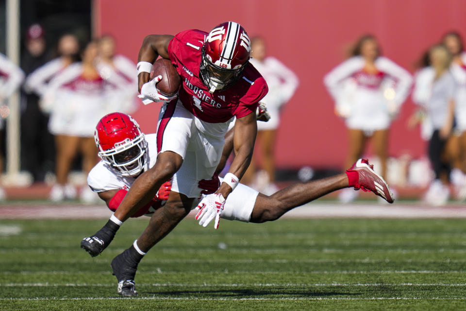 Indiana wide receiver Donaven McCulley (1) breaks the tackle of Rutgers defensive back Max Melton (16) during the second half of an NCAA college football game in Bloomington, Ind., Saturday, Oct. 21, 2023. Rutgers won 31-14. (AP Photo/Michael Conroy)