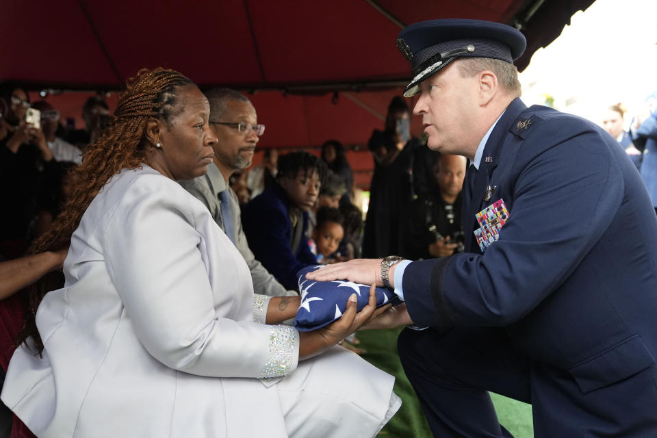 Chantemekki Fortson, the mother of slain airman Roger Fortson, left, receives the U.S. burial flag during his interment at Lincoln Memorial Cemetery, Friday, May 17, 2024, in Atlanta. (AP Photo/Brynn Anderson)