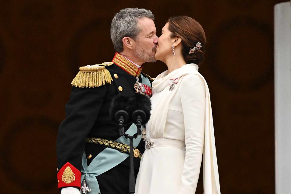 <p>JONATHAN NACKSTRAND/AFP via Getty </p> King Frederik and Queen Mary of Denmark kiss during first appearance of reign on Jan. 14, 2024