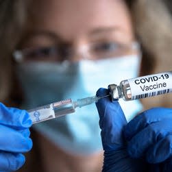 A health care worker fills a syringe with the COVID-19 vaccine.