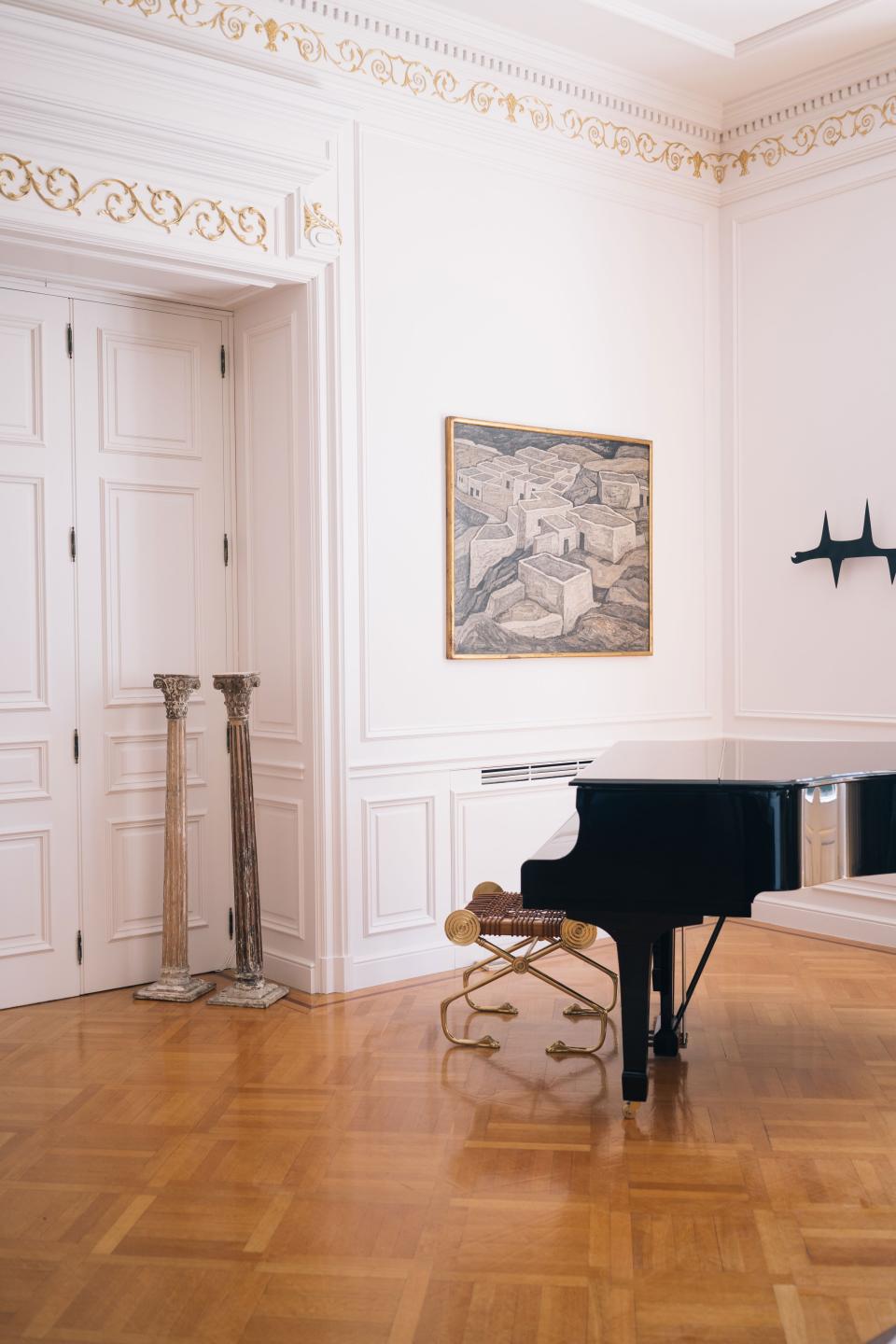 The piano, with a bench by Saridis, sits under Minotaur, an iron sculpture by artist Alex Mylona. The painting is 3 Skyros by 20th-century artist Giorgos Sikeliotis.