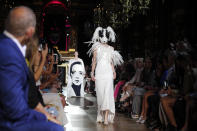 <p>Im Palais Garnier schritt ein Model über den Laufsteg, das ein schlichtes Abendkleid in Kombination mit einer edlen Hundemaske präsentierte. Die Ohren waren aus großen Federn gefertigt, die sich auch am Ausschnitt der Robe wiederfanden. (Bild: AP Photo) </p>