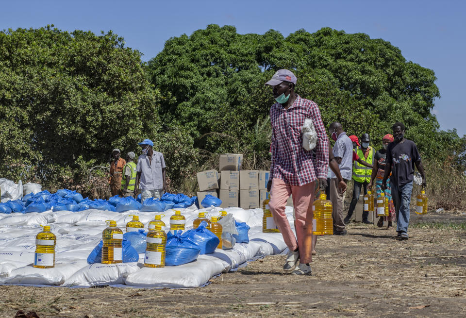 In this handout photo provided by the World Food Program on Tuesday, Sept. 22, 2020, people wait to collect food parcels in Cabo Delgado Province, Mozambique, Thursday, Aug. 27, 2020. The WFP says the escalating extremist insurgency in northern Mozambique has displaced 310,000 people, creating an urgent humanitarian crisis. (Falume Bachir/World Food Program via AP)