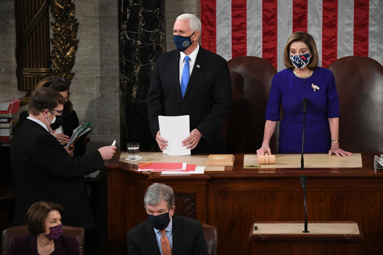 Vice President Mike Pence stands at a desk with House Speaker Nancy Pelosi next to him as he presides over a joint session of Congress.