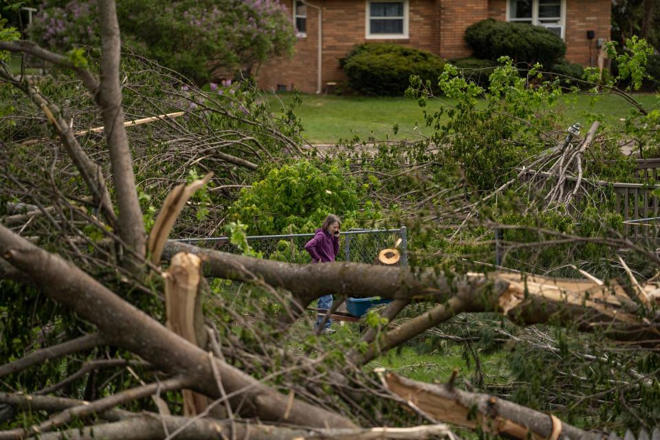 A woman stands surrounded by downed trees in her yard in Gaylord on Monday, May 23, 2022, following the  EF-3 tornado, which ripped through with winds at 150 mph, hit the area damaging many of the surrounding homes.