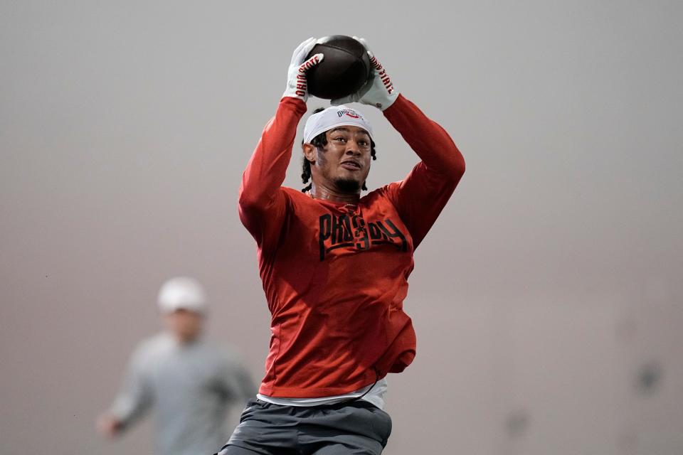 Ohio State wide receiver Jaxon Smith-Njigba catches a ball during pro day.