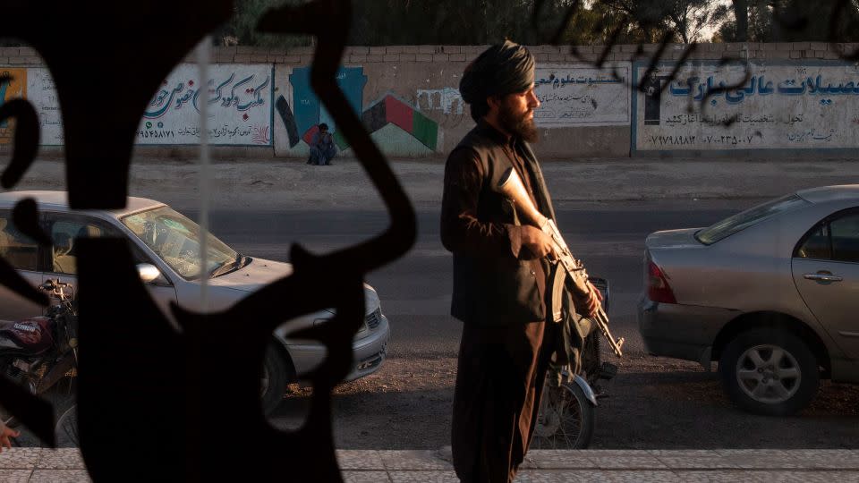 A Taliban fighter stands in front of a men's barber shop in Zaranj, the capital of Afghanistan's Nimroz province, on October 14, 2021. - Majid Saeedi/Getty Images/File