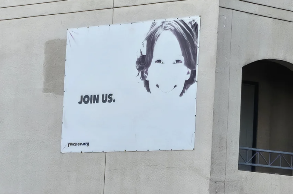 Banner with a child's face and the text "JOIN US." seen on a building exterior, promoting the organization yccejg.org