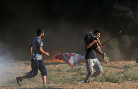 A wounded Palestinian is evacuated during a protest demanding the right to return to their homeland at the Israel-Gaza border, in Gaza August 17, 2018. REUTERS/Mohammed Salem