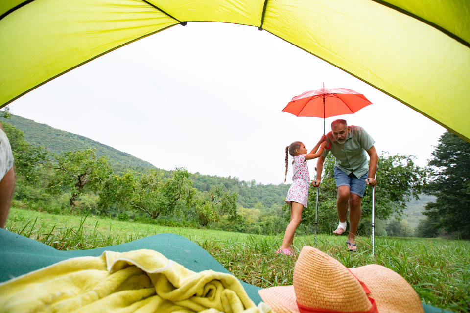 Daughter Helping Injured Father During Camping Vacations