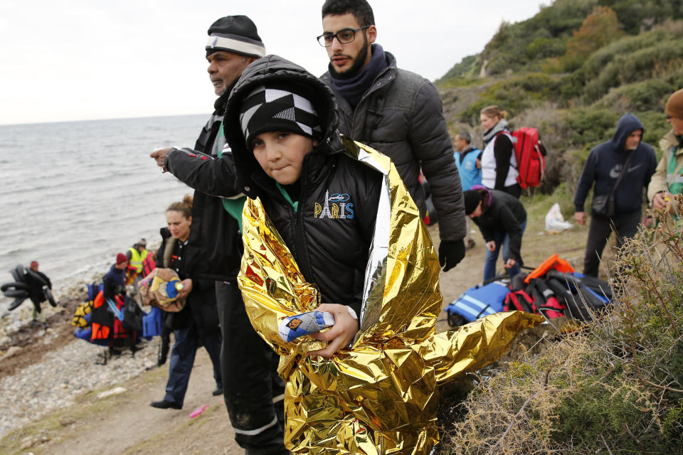 A boy wrapped in a thermal blanket holds a pair of dry socks after arriving to Lesbos on Jan. 29, 2016.