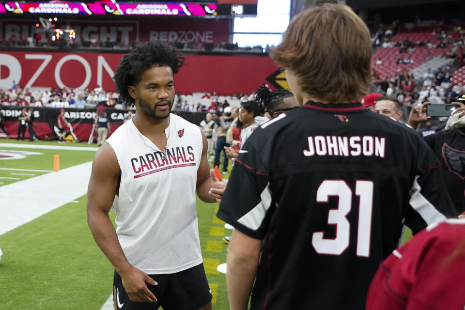 Arizona Cardinals quarterback Kyler Murray, left, speaks with fanms before an NFL football game against the Dallas Cowboys, Sunday, Sept. 24, 2023, in Glendale, Ariz. (AP Photo/Ross D. Franklin)