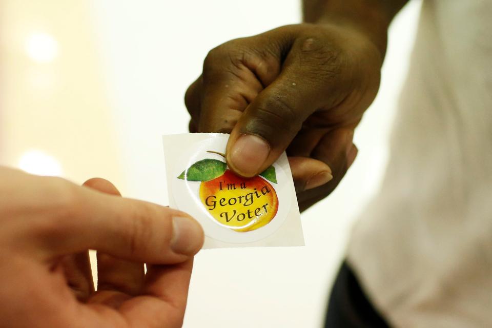 A voter picks up an "I'm a Georgia Voter" sticker after voting at Clarke Central High School in Athens on Tuesday, Nov. 3.