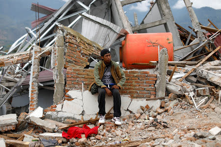 Nofal Surya, 37, sits on bricks that used to be his home hit by an earthquake, in Balaroa neighbourhood, Palu, Central Sulawesi, Indonesia, October 11, 2018. REUTERS/Jorge Silva